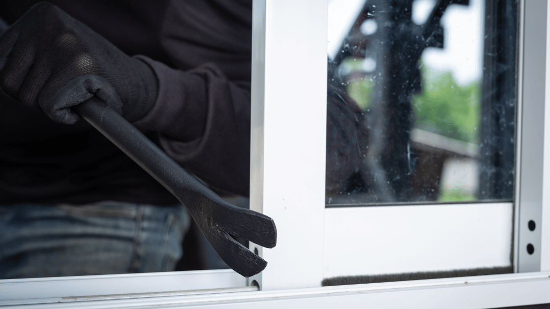 Homem abrindo uma janela com pé de cabra