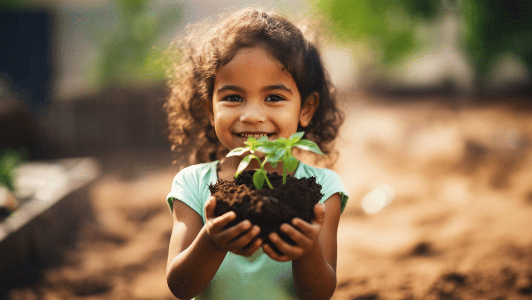 Criança sorrindo segurando uma planta